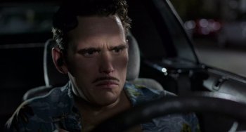 Movie still from “There's Something About Mary” (1998), directed by Bobby Farrelly – A man with a mustache driving in a car at night; Close Up shot, Low angle