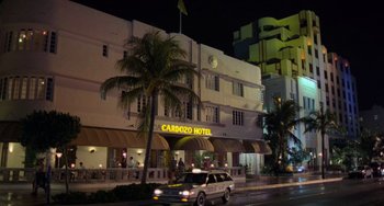 Movie still from “There's Something About Mary” (1998), directed by Bobby Farrelly – A car driving down a street near a building; Extreme Wide shot, Low angle