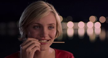 Movie still from “There's Something About Mary” (1998), directed by Bobby Farrelly – A woman is holding a chopstick in her mouth; Close Up shot, Over the shoulder angle