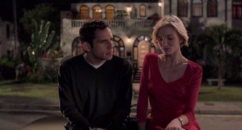 Movie still from “There's Something About Mary” (1998), directed by Bobby Farrelly – A man and a woman sitting next to each other in front of a building; Medium shot, Over the shoulder angle