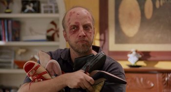 Movie still from “There's Something About Mary” (1998), directed by Bobby Farrelly – A bald man with a lot of makeup on his face; Medium shot, Low angle