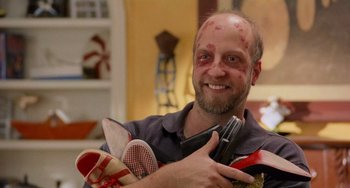 Movie still from “There's Something About Mary” (1998), directed by Bobby Farrelly – A man holding a pair of shoes in his hands; Close Up shot, Overhead angle