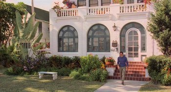 Movie still from “There's Something About Mary” (1998), directed by Bobby Farrelly – A man walking in front of a white building; Wide shot, Low angle