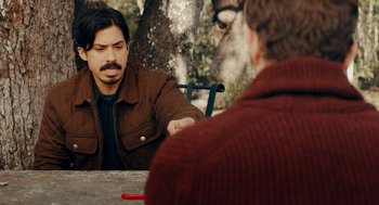 Movie still from “There's Something Wrong with the Children” (2023), directed by Roxanne Benjamin – A man sitting in front of another man at a table; Medium shot, Over the shoulder angle