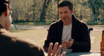 Movie still from “There's Something Wrong with the Children” (2023), directed by Roxanne Benjamin – A man sitting in front of another man in a park; Medium shot, Over the shoulder angle