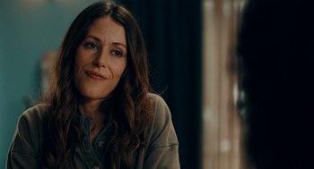 Movie still from “There's Something Wrong with the Children” (2023), directed by Roxanne Benjamin – A person sitting in front of a window; Close Up shot, Over the shoulder angle