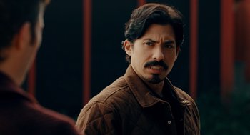 Movie still from “There's Something Wrong with the Children” (2023), directed by Roxanne Benjamin – A person wearing a jacket; Close Up shot, Over the shoulder angle