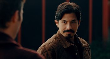 Movie still from “There's Something Wrong with the Children” (2023), directed by Roxanne Benjamin – A person wearing a jacket; Close Up shot, Over the shoulder angle