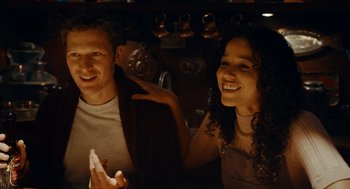 Movie still from “There's Something Wrong with the Children” (2023), directed by Roxanne Benjamin – A man and a woman smile for the camera; Medium shot, Low angle