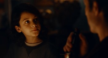 Movie still from “There's Something Wrong with the Children” (2023), directed by Roxanne Benjamin – A young girl is looking at the camera; Close Up shot, Over the shoulder angle