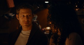 Movie still from “There's Something Wrong with the Children” (2023), directed by Roxanne Benjamin – A man and a woman standing next to each other in a dark room; Close Up shot, Over the shoulder angle