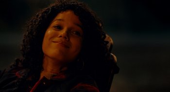 Movie still from “There's Something Wrong with the Children” (2023), directed by Roxanne Benjamin – A young woman sitting in a chair with her eyes closed; Close Up shot, Over the shoulder angle