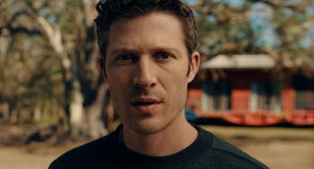 Movie still from “There's Something Wrong with the Children” (2023), directed by Roxanne Benjamin – A person wearing a black shirt; Close Up shot, Low angle