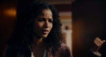 Movie still from “There's Something Wrong with the Children” (2023), directed by Roxanne Benjamin – A person with curly black hair; Close Up shot, Over the shoulder angle