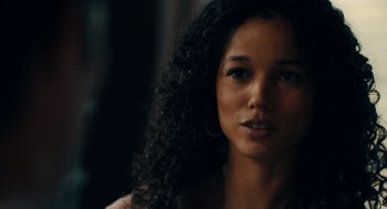 Movie still from “There's Something Wrong with the Children” (2023), directed by Roxanne Benjamin – A person with curly black hair; Close Up shot, Over the shoulder angle