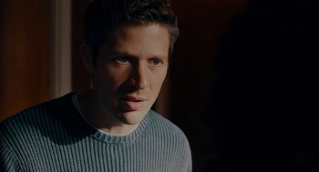 Movie still from “There's Something Wrong with the Children” (2023), directed by Roxanne Benjamin – A person wearing a blue sweater; Close Up shot, Over the shoulder angle