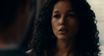 Movie still from “There's Something Wrong with the Children” (2023), directed by Roxanne Benjamin – A person with curly black hair; Close Up shot, Over the shoulder angle