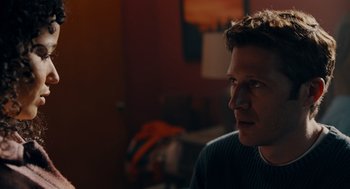 Movie still from “There's Something Wrong with the Children” (2023), directed by Roxanne Benjamin – A person sitting in a room; Close Up shot, Over the shoulder angle