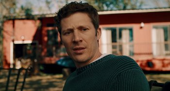 Movie still from “There's Something Wrong with the Children” (2023), directed by Roxanne Benjamin – A person wearing a sweater outside; Close Up shot, Over the shoulder angle