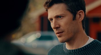 Movie still from “There's Something Wrong with the Children” (2023), directed by Roxanne Benjamin – A person wearing a sweater; Close Up shot, Over the shoulder angle