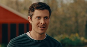 Movie still from “There's Something Wrong with the Children” (2023), directed by Roxanne Benjamin – A person wearing a green sweater; Close Up shot, Over the shoulder angle