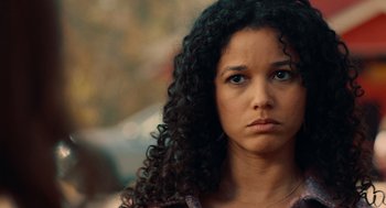 Movie still from “There's Something Wrong with the Children” (2023), directed by Roxanne Benjamin – A person with curly black hair; Close Up shot, Over the shoulder angle