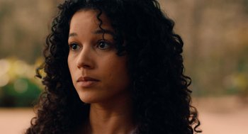 Movie still from “There's Something Wrong with the Children” (2023), directed by Roxanne Benjamin – A person with curly hair; Close Up shot, Over the shoulder angle