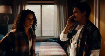 Movie still from “There's Something Wrong with the Children” (2023), directed by Roxanne Benjamin – A man and a woman standing next to each other in front of a bed; Medium shot, Low angle