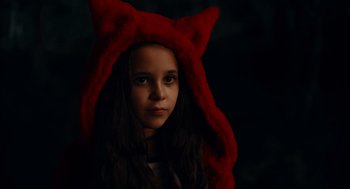 Movie still from “There's Something Wrong with the Children” (2023), directed by Roxanne Benjamin – A young girl wearing a red cat's ear hat; Close Up shot, High angle