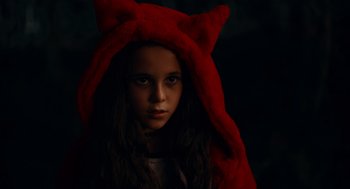 Movie still from “There's Something Wrong with the Children” (2023), directed by Roxanne Benjamin – A young girl wearing a red cat's ear hat; Close Up shot, High angle