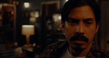 Movie still from “There's Something Wrong with the Children” (2023), directed by Roxanne Benjamin – A person with a beard and mustache; Close Up shot, Over the shoulder angle