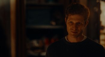 Movie still from “There's Something Wrong with the Children” (2023), directed by Roxanne Benjamin – A person wearing a sweater; Close Up shot, Over the shoulder angle