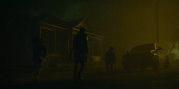 Movie still from “They Cloned Tyrone” (2023), directed by Juel Taylor – Two people walking on a street in the dark; Wide shot, Low angle