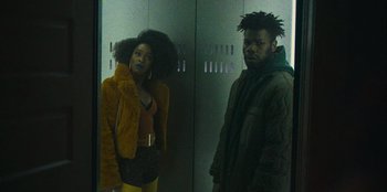 Movie still from “They Cloned Tyrone” (2023), directed by Juel Taylor – A man and a woman standing next to each other; Medium shot, Low angle