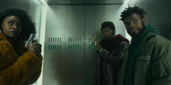 Movie still from “They Cloned Tyrone” (2023), directed by Juel Taylor – Two men standing next to each other in front of an elevator; Medium shot, Low angle