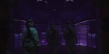 Movie still from “They Cloned Tyrone” (2023), directed by Juel Taylor – A group of people wearing protective suits in a dark room; Wide shot, Low angle