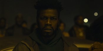 Movie still from “They Cloned Tyrone” (2023), directed by Juel Taylor – A person wearing a jacket; Close Up shot, Low angle