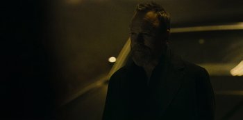 Movie still from “They Cloned Tyrone” (2023), directed by Juel Taylor – A man with a goatee and beard standing in the dark; Close Up shot, Low angle