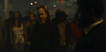 Movie still from “They Cloned Tyrone” (2023), directed by Juel Taylor – A group of people standing in the dark at night; Medium shot, Over the shoulder angle