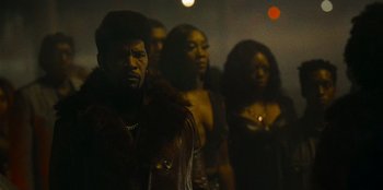 Movie still from “They Cloned Tyrone” (2023), directed by Juel Taylor – A group of men and women standing next to each other; Medium shot, Low angle