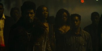 Movie still from “They Cloned Tyrone” (2023), directed by Juel Taylor – A group of people standing next to each other in the dark; Close Up shot, Low angle