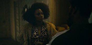 Movie still from “They Cloned Tyrone” (2023), directed by Juel Taylor – A woman in a leopard print jacket looking into a mirror; Close Up shot, Over the shoulder angle