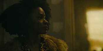Movie still from “They Cloned Tyrone” (2023), directed by Juel Taylor – A woman with a fur coat looking to her left; Close Up shot, Low angle