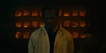 Movie still from “They Cloned Tyrone” (2023), directed by Juel Taylor – A man wearing a lab coat standing in front of shelves; Close Up shot, Low angle