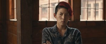 Movie still from “They/Them” (2022), directed by John Logan – A person with red hair and a camouflage shirt; Close Up shot, Over the shoulder angle