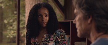 Movie still from “They/Them” (2022), directed by John Logan – A person with long black hair; Close Up shot, Over the shoulder angle