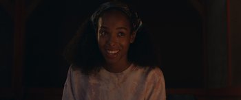 Movie still from “They/Them” (2022), directed by John Logan – A young woman smiles for the camera in the dark; Close Up shot, Over the shoulder angle