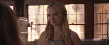 Movie still from “They/Them” (2022), directed by John Logan – A woman with long blonde hair wearing an apron; Close Up shot, Over the shoulder angle