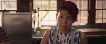 Movie still from “They/Them” (2022), directed by John Logan – A woman with red hair is wearing an apron; Close Up shot, Over the shoulder angle
