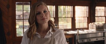 Movie still from “They/Them” (2022), directed by John Logan – A woman wearing an apron standing next to a window; Close Up shot, Over the shoulder angle
